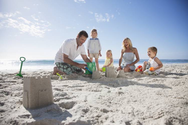 family making sandcastle on beach
