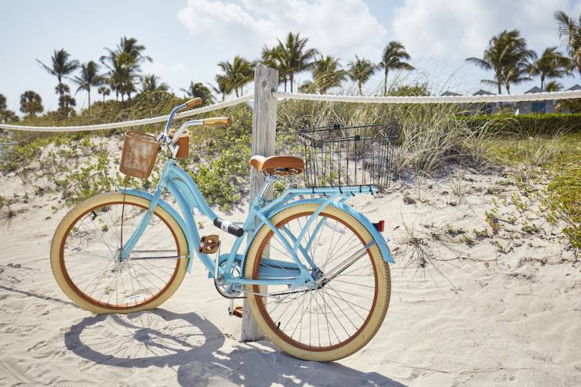 bike leaning on rope fence at beach