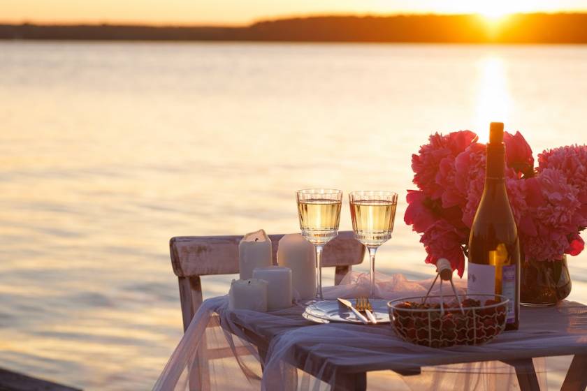 Flowers and cups on a table during a romantic sunset cruise